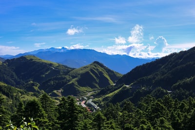 白天蓝天下山上的绿树